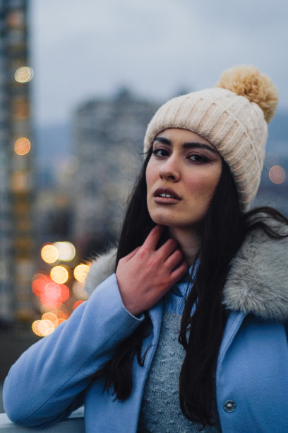 一个深色头发的年轻人在城里拍了一幅冬季帽子的肖像图片下载