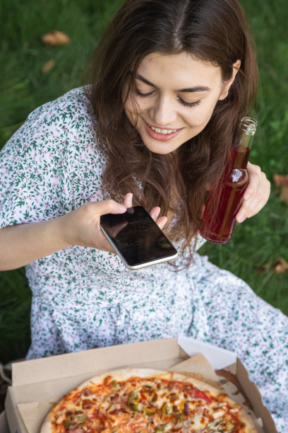 一个年轻女人做披萨的照片，野餐的概念。图片下载
