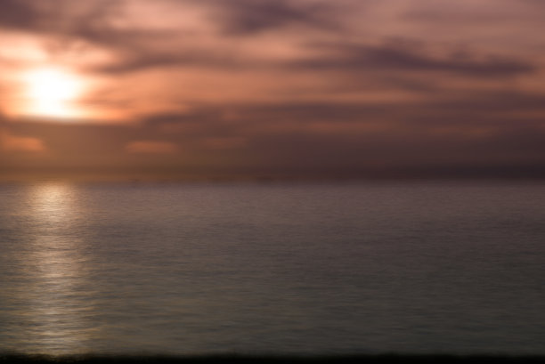 日出或日落的景色在海面上有美丽的金色倒影。图片下载