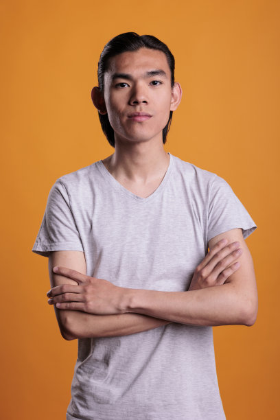 严肃的年轻亚洲人站在自信的姿势图片下载