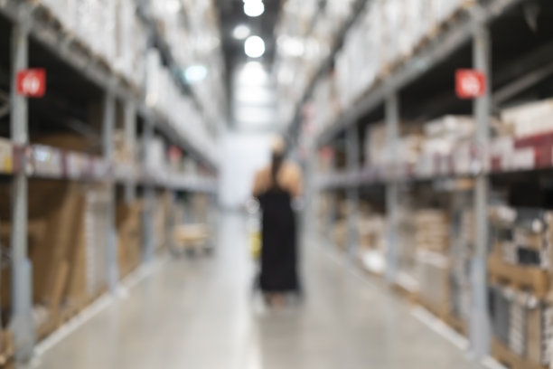 模糊了周末在批发商店等待忙碌的购物者。图片下载