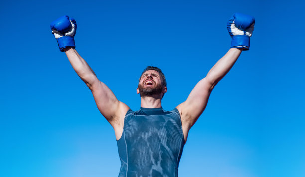 戴着拳击手套的快乐拳击手庆祝成功，运动图片下载