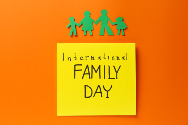 纸剪纸和卡片与文字国际家庭日在橙色的背景，平lay图片下载