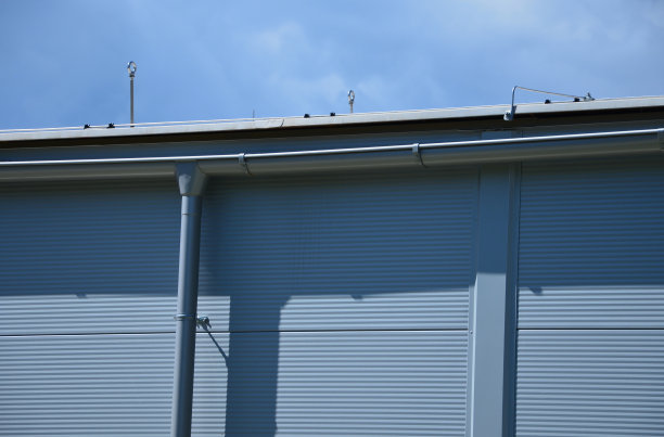 黄色的建筑内衬着方形的塑料板、玻璃纤维。用螺丝固定。可清洗的墙壁是一个主要优点。平屋顶阁楼上的接地线、避雷针、天沟、锡图片下载