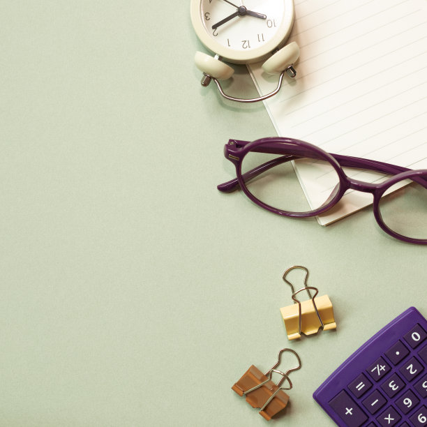 办公桌上有笔记本，眼镜，时钟，夹子，计算器，绿色的桌子上的用品。平铺，俯视图，拷贝空间图片下载