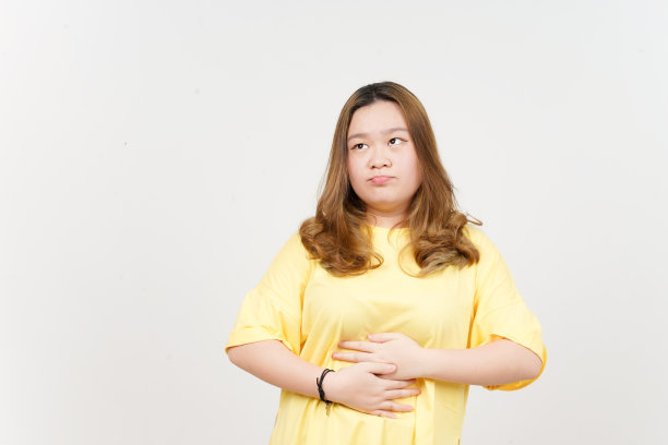 肚子痛的姿势想想食物，饥饿的概念漂亮的亚洲女人穿着黄色的t恤图片下载