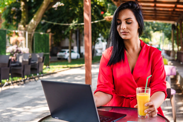 一位年轻女子在咖啡馆用笔记本电脑工作图片下载