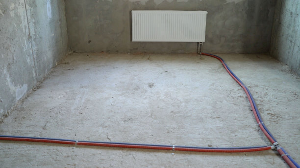 一套新公寓的地板上有自来水线。地板上有蓝色和红色的水管。临时通讯:在建筑物修理或建造期间的临时供热和供水的通讯图片下载