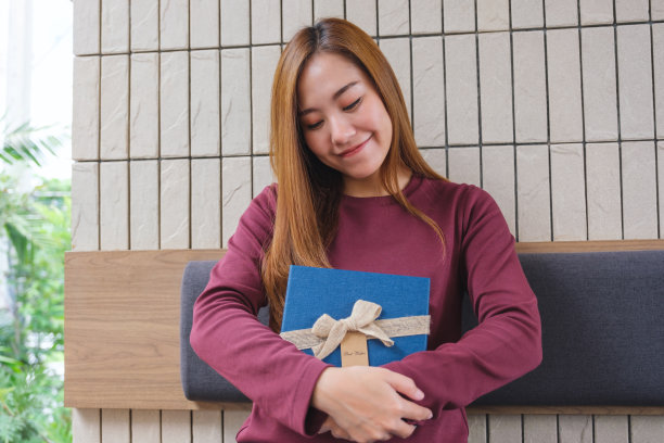 一个年轻女子接受并拿着一个礼物盒的肖像图像图片下载