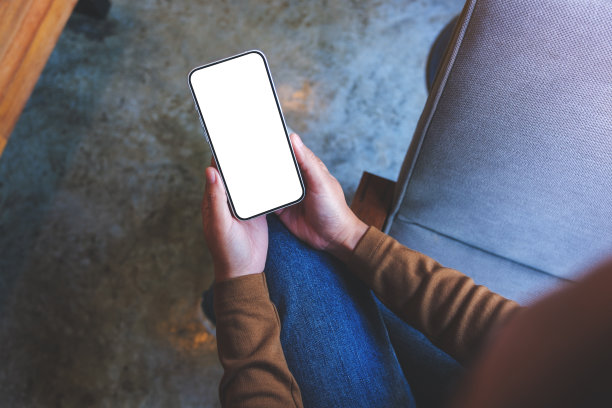 俯视图模拟形象的一个女人拿着手机与空白桌面屏幕图片下载