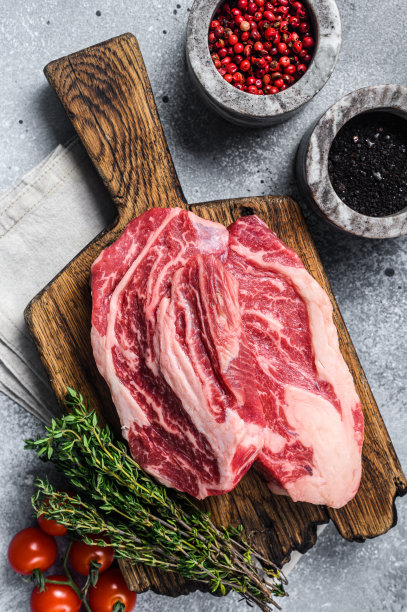 用百里香把牛肉卷放在木板上。灰色的背景。俯视图图片下载
