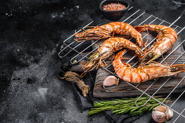 烤大黑虎虾，烤虾。黑色背景。前视图。免费空间图片下载