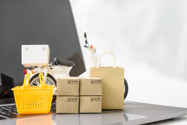 网上购物的电子商务和配送服务:配送摩托车、家用购物篮、包裹盒、笔记本电脑上的购物袋。送货上门服务。图片下载