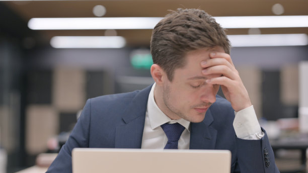 生意人坐着工作时头痛图片下载