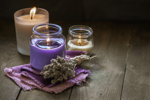 玻璃瓶薰衣草精油干籽香薰水疗按摩概念。药草紫色蜡烛木头桌子背景海盐静物质朴的砧板餐巾图片下载