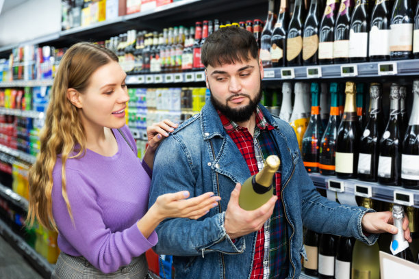 一对夫妇在杂货店挑选起泡酒图片下载