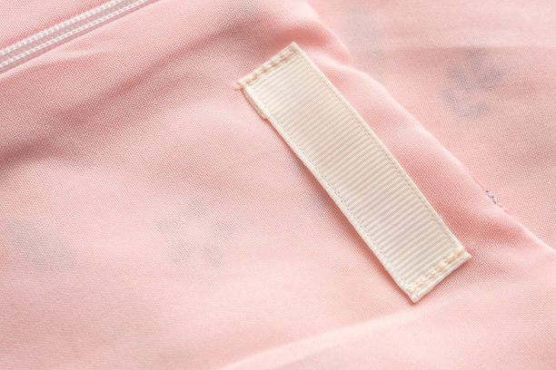 在织物纹理背景上的空白洗衣护理衣服标签图片下载