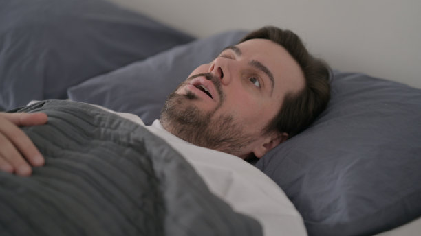 年轻人从床上的噩梦中醒来图片下载