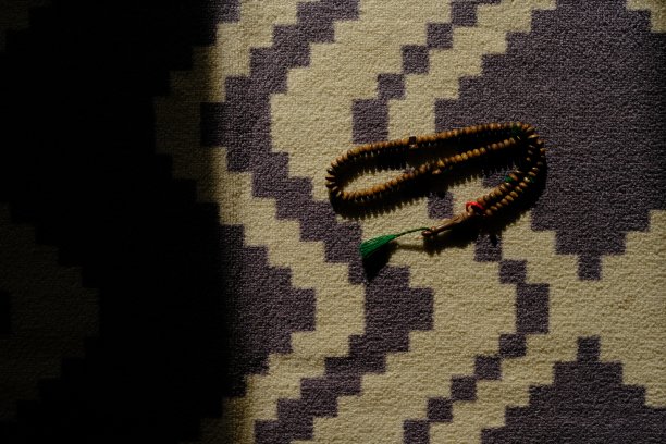 地毯上的念珠有晨曦的影子图片下载