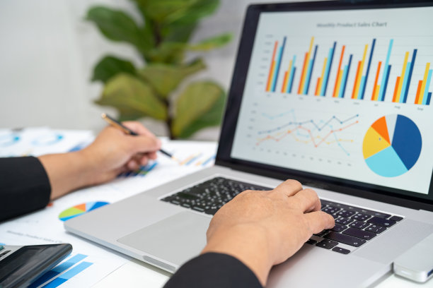 亚洲会计人员在现代办公、财务和商业观念中运用图表和计算器进行财务报告分析。图片下载