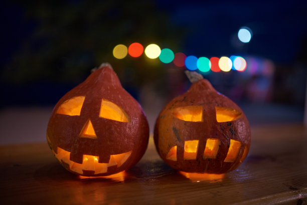 两个雕刻的南瓜在晚上的万圣节庆祝活动在城市。图片下载