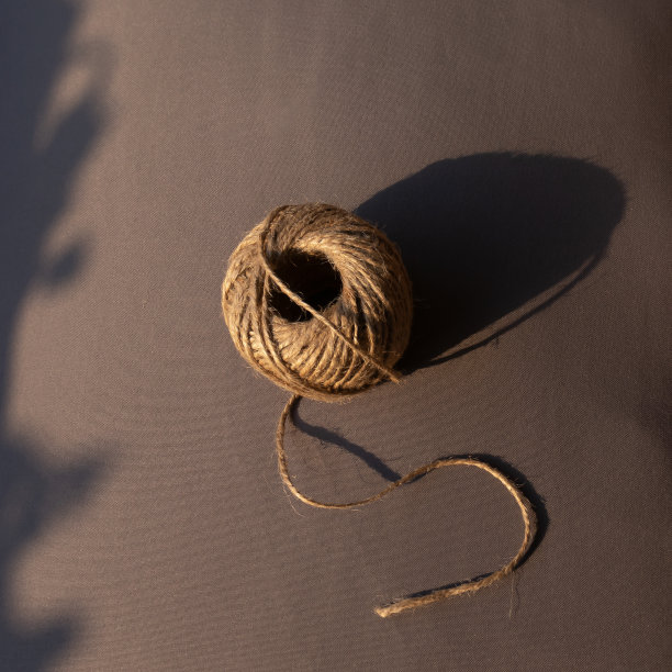 自然黄麻绳线圈孤立在灰色背景与阴影。图片下载