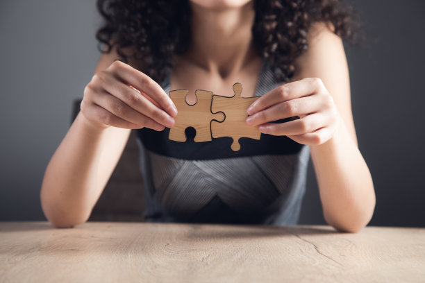 女人拿着一块木制的拼图图片下载