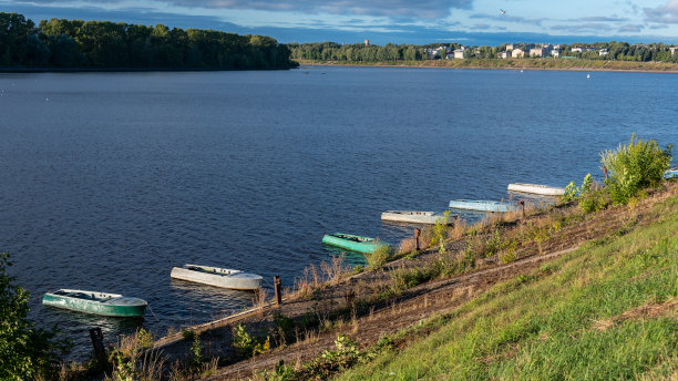 渔船系在河岸上，以水和城市景观为背景。图片下载