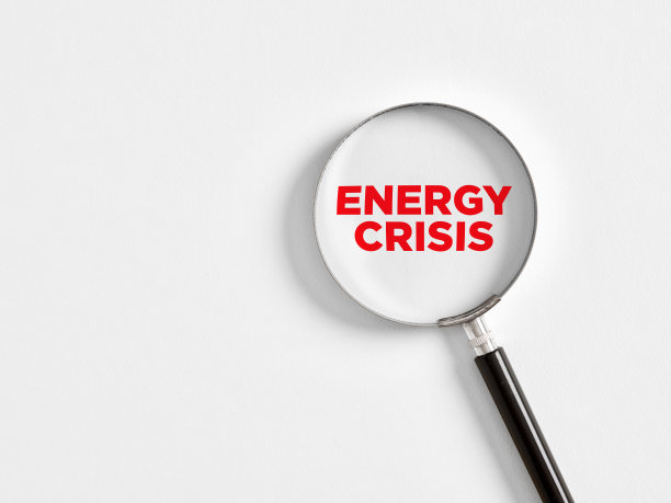分析或关注能源危机。放大镜放大了白色背景上的“能源危机”一词。图片下载