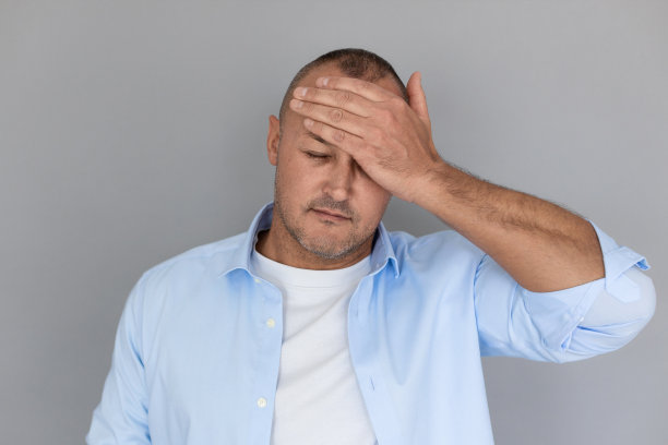 成熟白人男子触摸前额的肖像图片下载