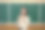 年轻漂亮的老师上化学课，站在黑板旁拿着化学式图片下载