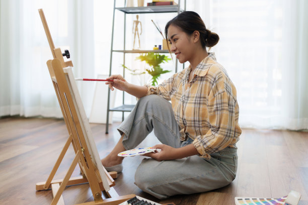 快乐的年轻女艺术家在画布上作画图片下载