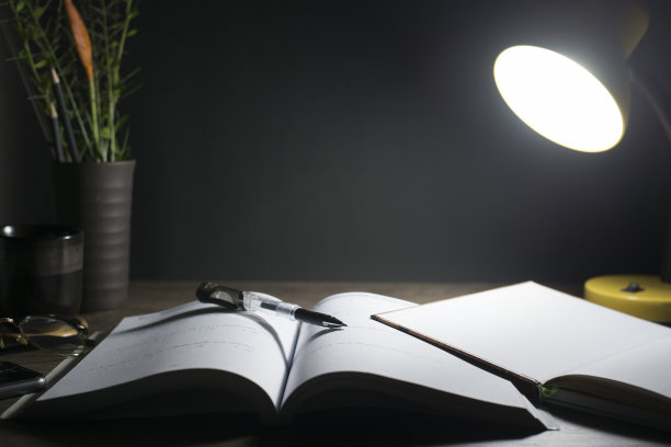 晚上的阅读桌，打开桌上的书，特写笔尖，拷贝空间。图片下载