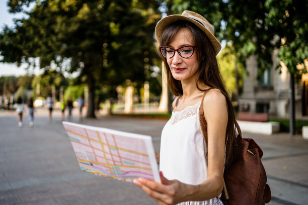 去欧洲旅游，年轻女游客在街上看地图，暑假。图片下载