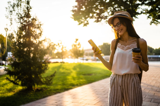 微笑的年轻女子使用手机图片下载