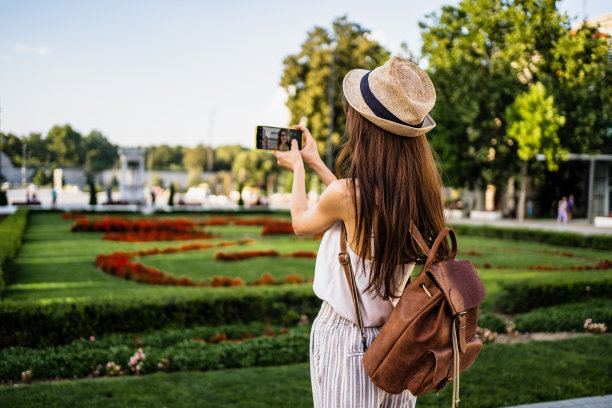 一名年轻女子在城市里走来走去，用她的手机拍下了这座城市图片下载