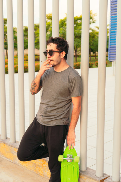 一个在阳光明媚的日子里抽烟的潮人图片下载
