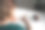 穿着绿色t恤的年轻女子坐在桌子旁用铅笔画画。图片下载