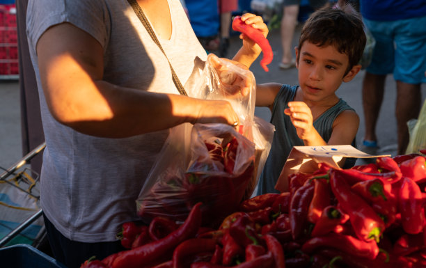 奶奶和孙子在农贸市场购买红甜椒照片图片下载