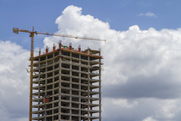 高耸的混凝土建筑与起重机在阴天水平施工照片图片下载