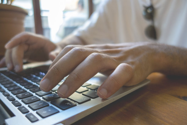 在笔记本电脑上打字的手的特写。夜间工作的概念。库存图片图片下载