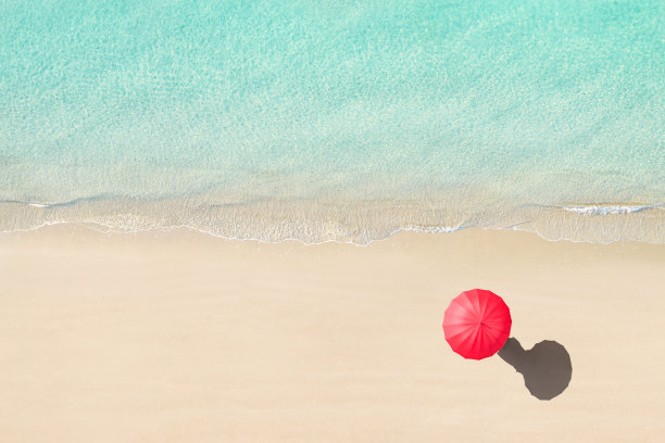 顶视图的女人与红色的夏天伞走在热带塞舌尔沙滩。蓝色、蓝绿色透明海水、海水、泻湖的水面。空中,无人机视图图片下载