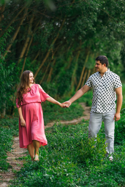 丈夫拥抱穿着粉色裙子的怀孕妻子。准父母w图片下载