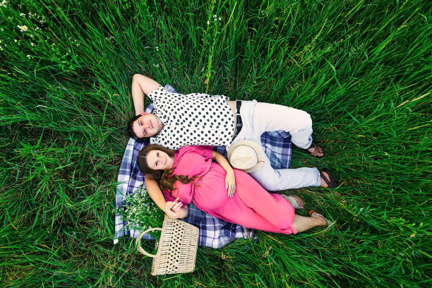 俯瞰年轻的家庭。男人和女人躺在一条毯子上图片下载