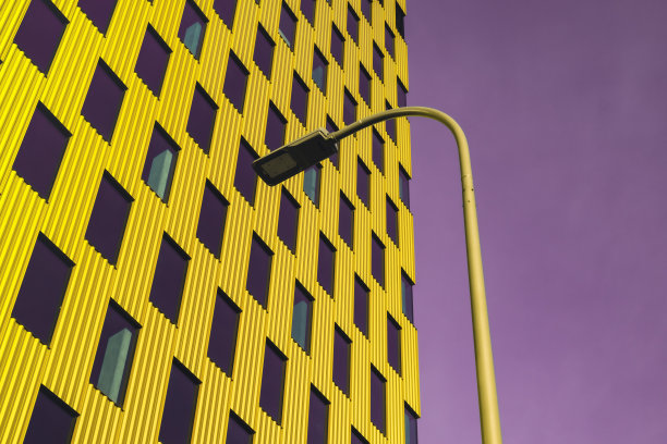 现代办公建筑外观与玻璃立面上清楚的紫色背景。鲜艳的颜色写字楼透明玻璃墙，黄色装饰，配上灯笼图片下载