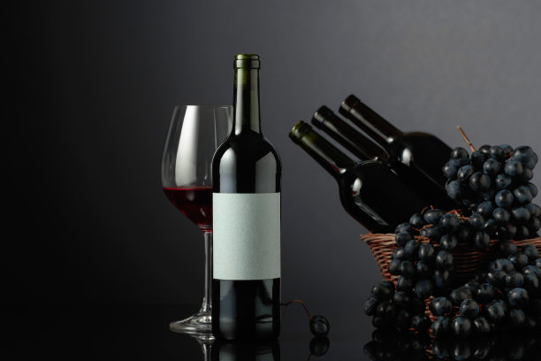 红酒和蓝葡萄在黑色反光的背景。图片下载