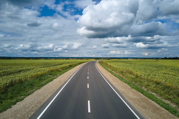 绿色农田之间空荡荡的城际道路鸟瞰图。从无人机俯瞰高速公路图片下载