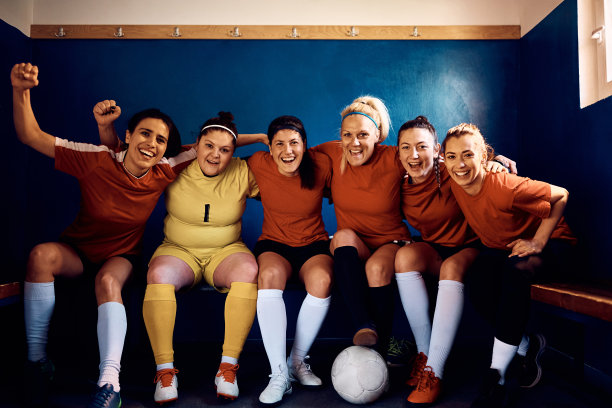 欢快的女足队员在更衣室里看着镜头。图片下载