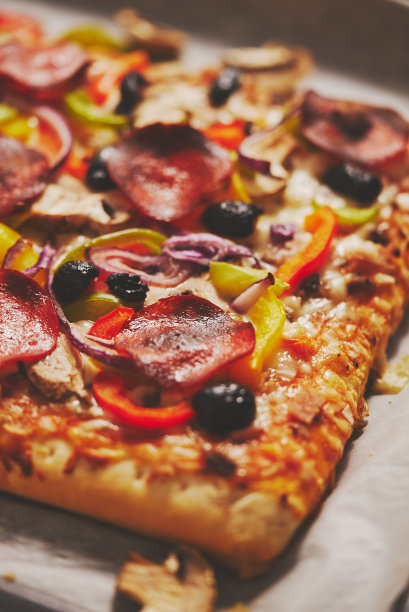 一块方形披萨，罗勒香肠，西红柿和蘑菇放在铁盘上图片下载