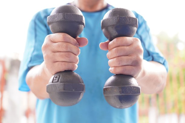 运动:图中展示的是两个哑铃的各种姿势的举重示范，特写，户外运动。图片下载